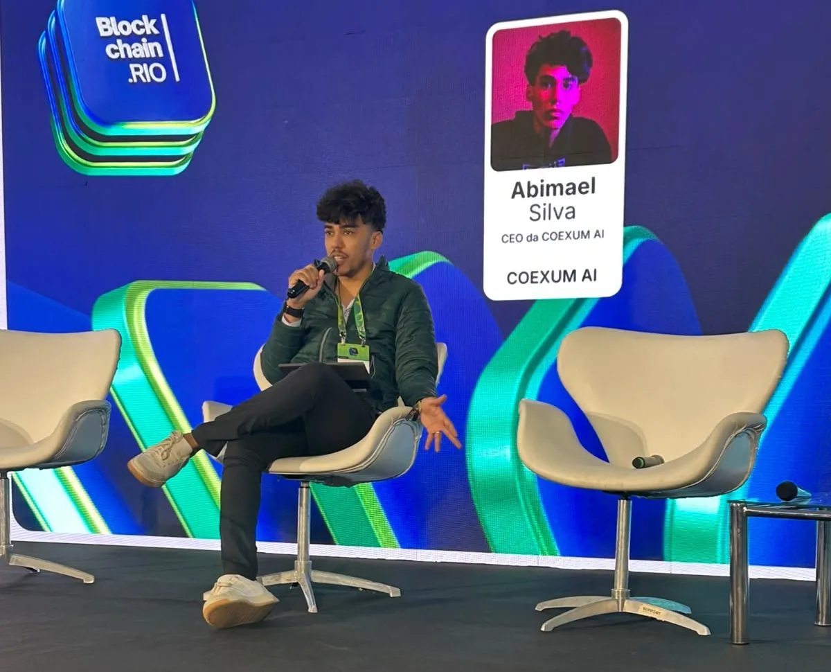Abimael Silva em painel no Blockchain.RIO, com o telão identificando o CEO da Coexum AI