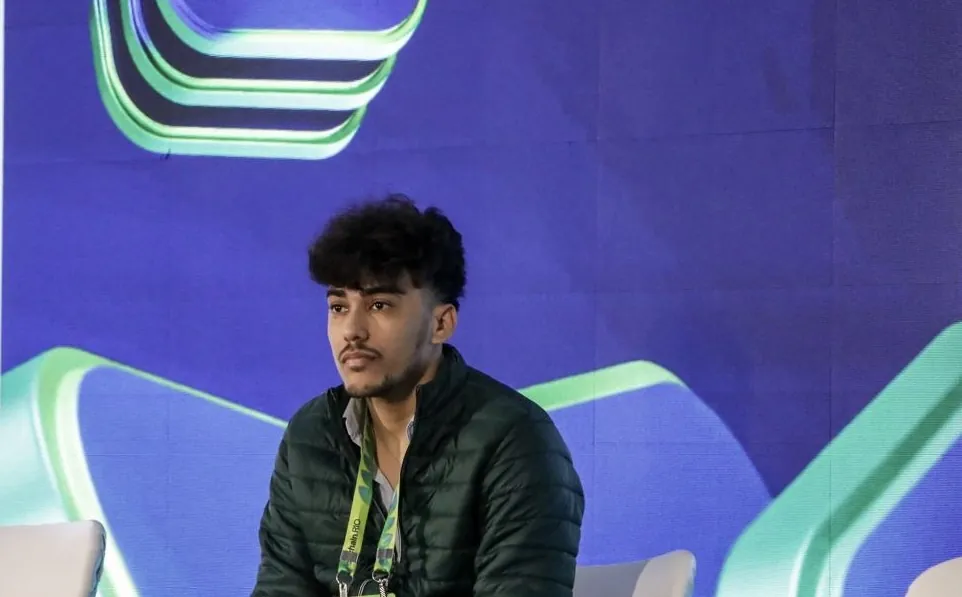 Abimael sentado no palco, diante do telão do evento